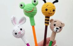 four crocheted animal pencils in the shape of animals with faces on them