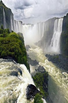 the water is very high and it looks like they are floating in the middle of the waterfall