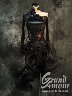 a mannequin is dressed in black leather and has flowers on the bustle