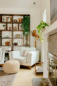 a living room filled with furniture and a fire place in front of a book shelf