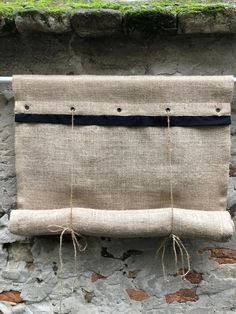 a piece of burlock hanging on the side of a stone wall with rope attached to it