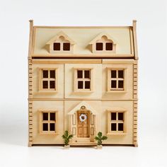 a wooden doll house with windows and a clock on the front door is shown against a white background