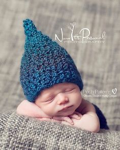 a newborn baby wearing a blue knitted hat