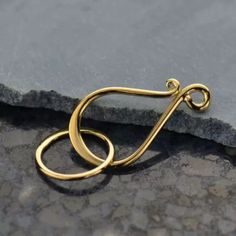 a gold ring sitting on top of a stone floor next to a gray rock wall