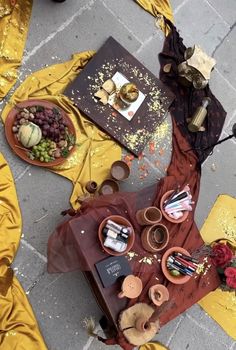 an overhead view of a table set up with food and drinks on it, surrounded by yellow cloths