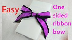 a white box with a purple ribbon on it and the words easy one sided ribbon bow