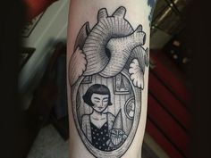 a tattoo on the arm of a woman with a heart in her hand and an animal inside