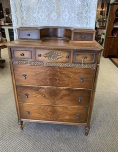 an old wooden dresser sitting on top of a carpeted floor in front of a wall