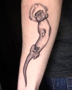 an otter tattoo on the left arm