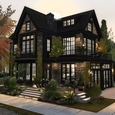 a large black house with lots of windows and plants on the front porch, along with steps leading up to it