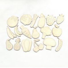 wooden cutouts of fruits and vegetables on a white background