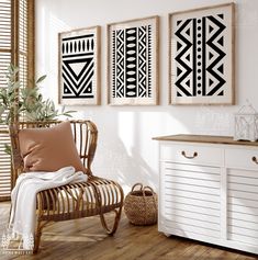 three black and white art prints hanging on the wall above a chair with a pillow