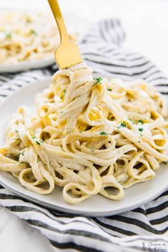 a white plate topped with pasta covered in sauce