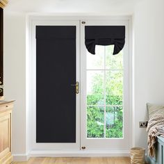 a bedroom with a bed, dresser and black curtains on the window sill in front of the sliding glass door