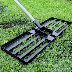 a lawn mower laying in the grass on top of it's side with two blades