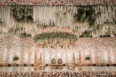 the wedding stage is decorated with flowers and greenery for an elegant touch to the venue