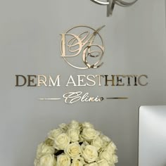 a bouquet of white roses sitting in front of a sign for derm aesthetic clinic