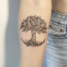 a woman's arm with a tree tattoo on it