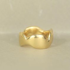 a close up of a gold ring on a white surface