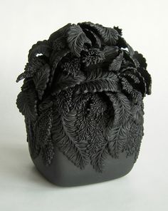 a black vase sitting on top of a white table