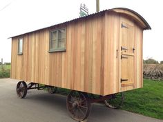 an old fashioned wooden wagon is parked on the road