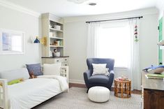 a child's bedroom with a blue chair and white bed