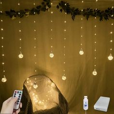 a person is holding a remote control in front of a screen with lights on it