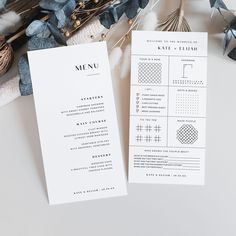 two wedding program cards sitting on top of a table next to some flowers and feathers