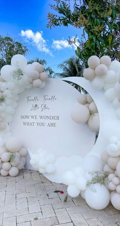 an arch made out of balloons with the words how we wonder what you are