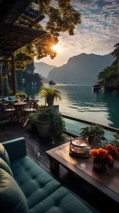 the sun is setting over an outdoor patio with tables and chairs on it, overlooking a body of water