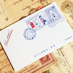 an envelope with chinese stamps on it sitting on top of some old postcards and letters