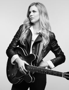 a woman holding a guitar in her hands