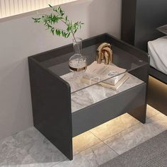 a glass table with some books and a vase on it next to a bed in a room