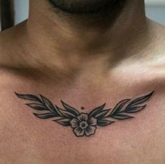 a close up of a man's chest with a flower tattoo on his chest