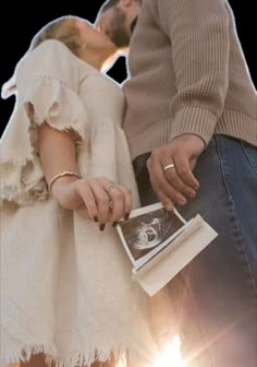 a man and woman standing next to each other with their hands on the back of them