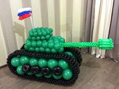 an inflatable tank is sitting on the floor with balloons attached to it's sides