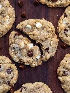 cookies with chocolate chips and marshmallows are on a wooden surface, ready to be eaten