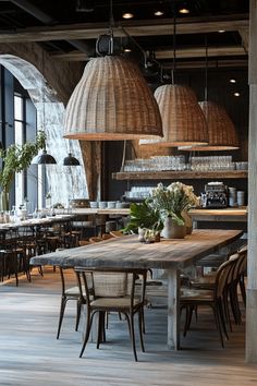 an industrial style dining room with wooden tables and hanging lights above the table are plants and flowers in vases