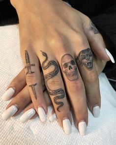 two hands with tattoos on them, one has a snake and the other has a skull