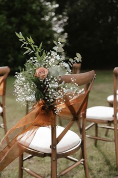 Wedding flower arrangement attached to the chair decorations with ribbon for the outdoor ceremony Flowers On Chair, Wedding Decor Aisle, Whimsical Wedding Inspiration, Wedding Chair Sashes, Barn Wedding Inspiration, Vintage Boho Wedding, Aisle Flowers