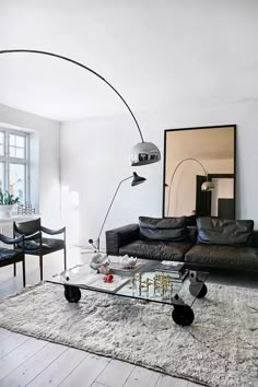 a living room filled with furniture and a large mirror on top of the wall next to a window