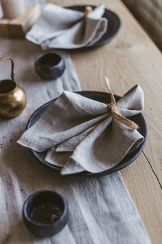 a table topped with black plates covered in napkins