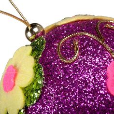 a close up of a purple purse with flowers on the front and side, hanging from a chain