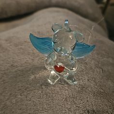 a clear glass figurine with a heart on it's chest and wings