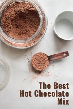 the best hot chocolate mix is in a glass bowl and next to two spoons