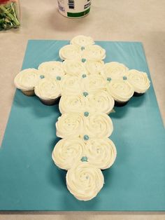 a cross made out of cupcakes sitting on top of a blue mat