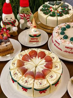 a table topped with lots of cakes covered in frosting and toppings on top of white plates