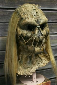 a creepy mask with long blonde hair on top of a table