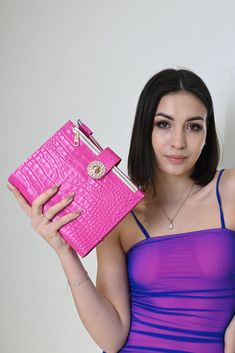 a woman in a purple dress holding a pink purse