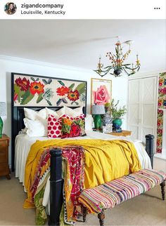 a bedroom decorated in bright colors with a large bed and chandelier above it